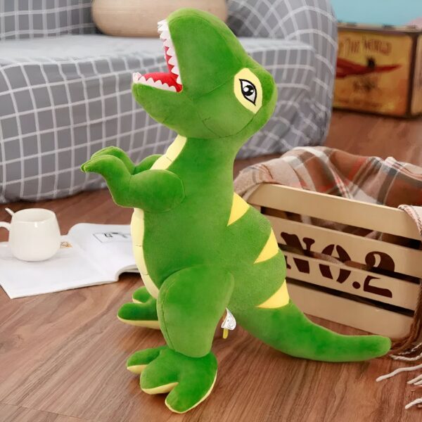 peluche-geante-t-rex-jouet-doux-pour-enfant-gardien-de-nuit-1a-2 Un dinosaure en peluche vert avec des yeux noirs et une bouche ouverte, debout sur un sol en bois.