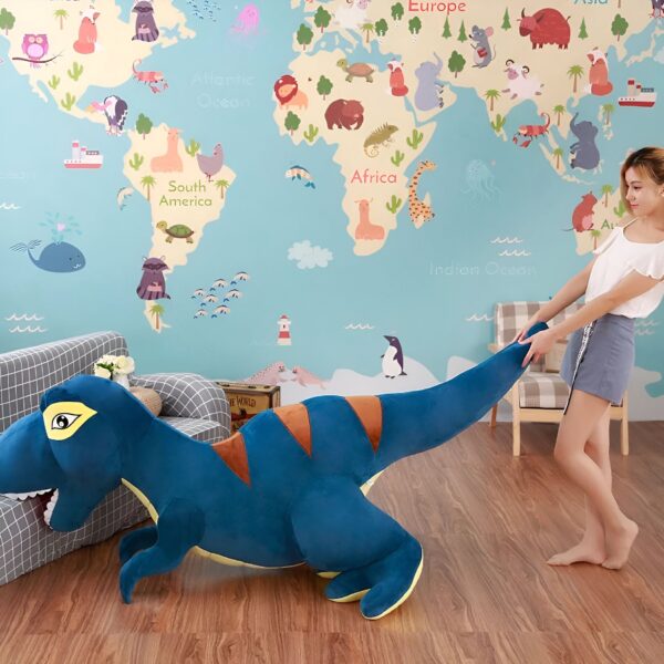 Une jeune fille joue avec un grand dinosaure en peluche bleu devant un mur avec une carte du monde.