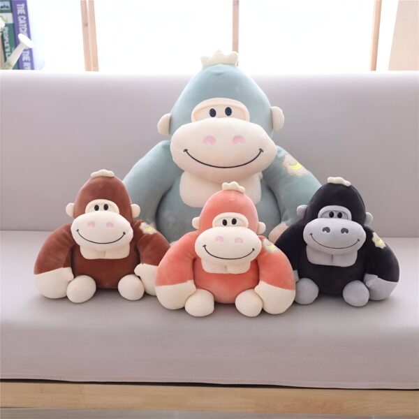peluche-gorille-marron-jouet-doux-et-amusant-cadeau-enfant-2a Une collection de quatre singes en peluche, deux petits et deux grands, de différentes couleurs, assis sur un canapé gris.