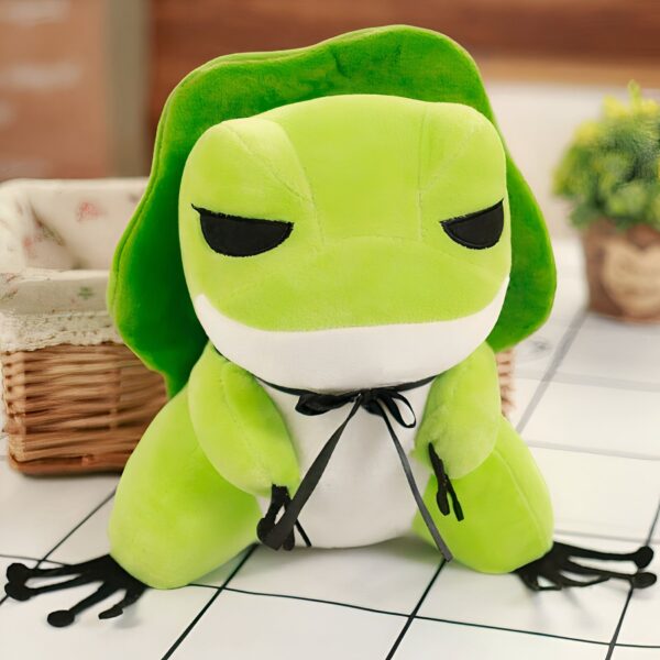 Une grenouille en peluche verte avec un nœud noir.