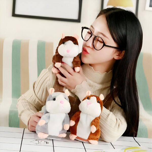 Une jeune femme tenant trois hamsters en peluche qui marchent.