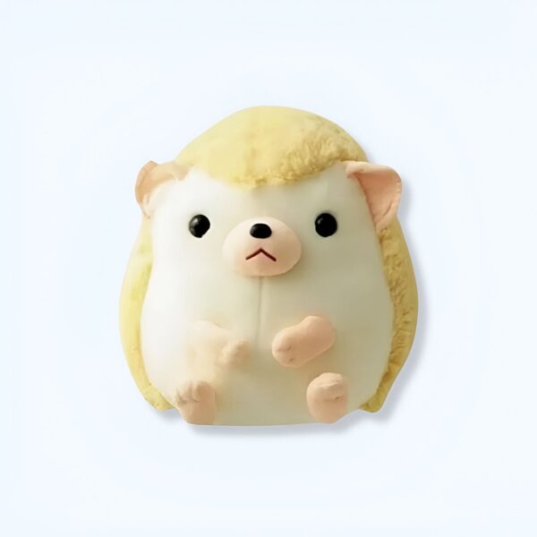 Une peluche de hérisson blanc avec des yeux noirs et un nez rose, assis sur un fond blanc.