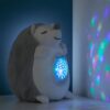 Une peluche en forme de hérisson projetant des étoiles et des formes colorées sur le mur.