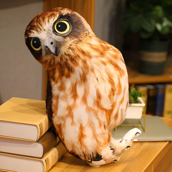 peluche-hibou-marron-et-blanc-50-cm-jouet-enfant-7a-1 Un coussin en forme de hibou brun avec de grands yeux jaunes, posé sur une pile de livres.