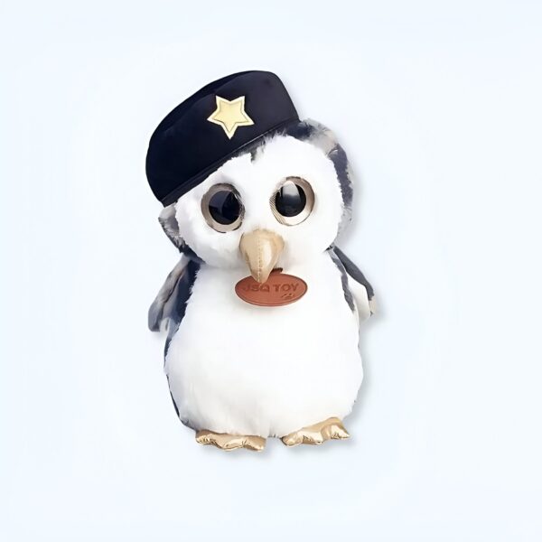Un adorable pingouin en peluche avec de grands yeux, portant une casquette noire avec une étoile dorée.