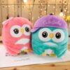 Deux hiboux en peluche, un rose avec un nœud et un bleu turquoise avec un chapeau mauve brodé "Cute Baby".