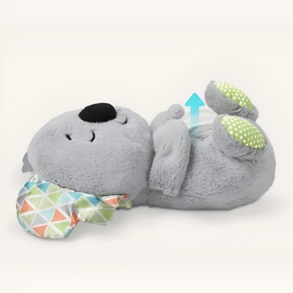 Jouet en peluche gris en forme de koala avec un ventre vert à pois blancs et un collier de triangles multicolores.