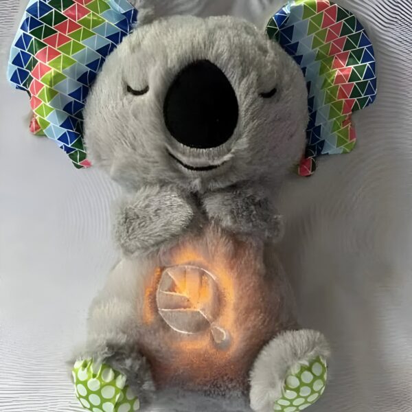 Une peluche grise de koala avec des oreilles colorées et une lumière qui éclaire le ventre.
