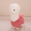 Peluche lama blanc avec un manteau rose.