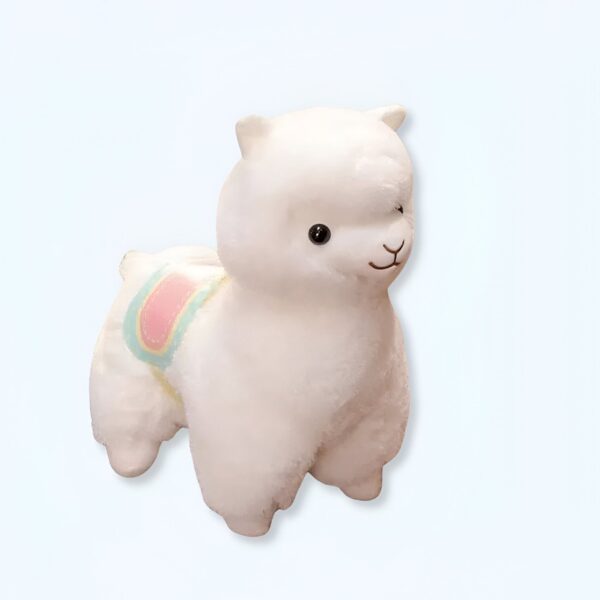 Peluche d'alpaga blanc avec une selle rose et bleue.