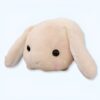 Un lapin en peluche beige avec de grands yeux noirs et des petites joues roses.