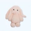 Un lapin en peluche rose assis sur un fond blanc.