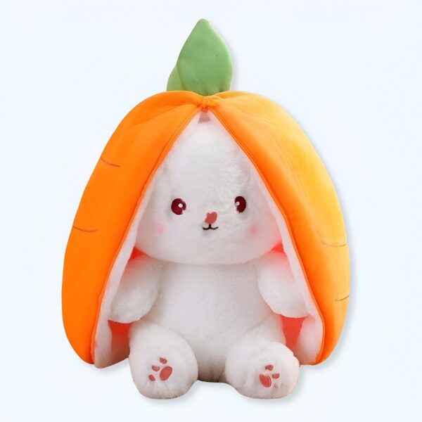 Un lapin en peluche blanc assis à l'intérieur d'une carotte orange en peluche. Le lapin a de grands yeux noirs, un petit nez rose et de petites pattes roses. La carotte a une feuille verte sur le dessus.