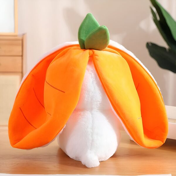 Un lapin en peluche blanc avec des oreilles orange en forme de carottes.