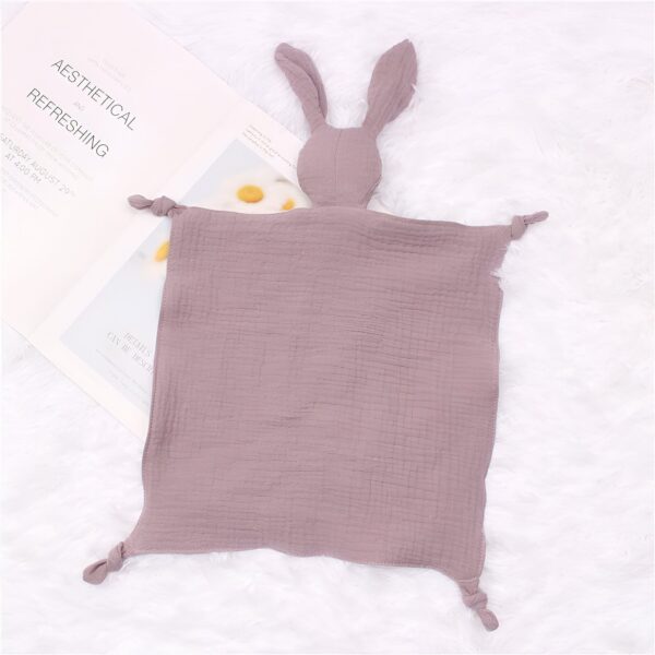 peluche-lapin-doudou-bebe-en-coton-et-mousseline-7a-2 Une couverture en mousseline de coton de couleur mauve avec des oreilles de lapin.