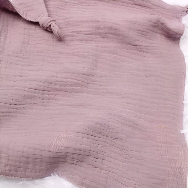 peluche-lapin-doudou-bebe-en-coton-et-mousseline-9a-1 Un tissu en gaze de coton rose pâle, doux et texturé, idéal pour les projets de couture et de bricolage.