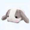 Un lapin en peluche gris et blanc avec de grands yeux noirs.