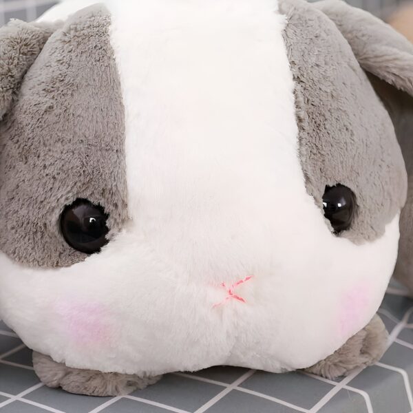 Un adorable lapin en peluche blanc et gris avec de grands yeux noirs et un petit nez rose.