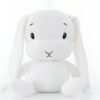 Un lapin en peluche blanc assis sur un fond blanc.