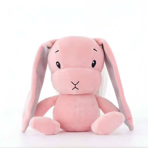 Un lapin en peluche rose assis sur un fond blanc.