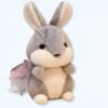 Un adorable lapin en peluche gris et blanc avec un noeud violet.