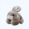 Un lapin en peluche gris avec de grandes oreilles et un museau blanc.