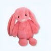 Peluche rose en forme de lapin avec de grandes oreilles, souriant.