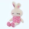Peluche lapin blanc portant un pyjama rose avec des imprimés de lapins et du texte "LOVE". Les yeux sont fermés et les oreilles sont longues et roses.