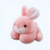 peluche-lapin-rose-tout-doux-1a Un lapin rose en peluche avec de longues oreilles et un visage mignon.