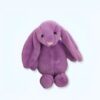 Lapin en peluche violet assis sur un fond blanc.