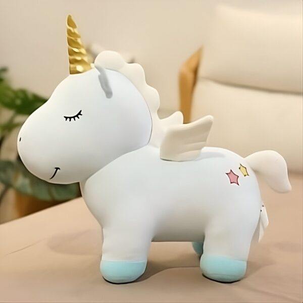 peluche-licorne-bleu-ailes-dorees-jouet-enfant-4a Une peluche de licorne blanche avec une corne dorée, des ailes et une queue. Elle est debout sur un fond beige.