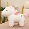 Une licorne en peluche blanche avec des ailes roses et une corne dorée.