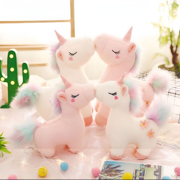 peluche-licorne-magique-douce-cadeau-enfant-3a-1 Quatre peluches de licornes roses et blanches avec des crinières et des queues arc-en-ciel se font face.