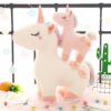 peluche-licorne-magique-douce-cadeau-enfant-5a-2 Deux licornes en peluche, une grande blanche avec une petite rose sur le dos, toutes les deux avec des fleurs brodées sur leur corps.