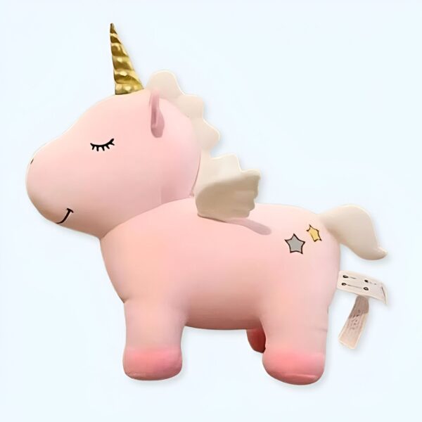 Une licorne rose en peluche avec une corne dorée, des ailes blanches et des étoiles jaunes sur son derrière.