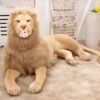 Un grand lion en peluche beige allongé sur le sol.