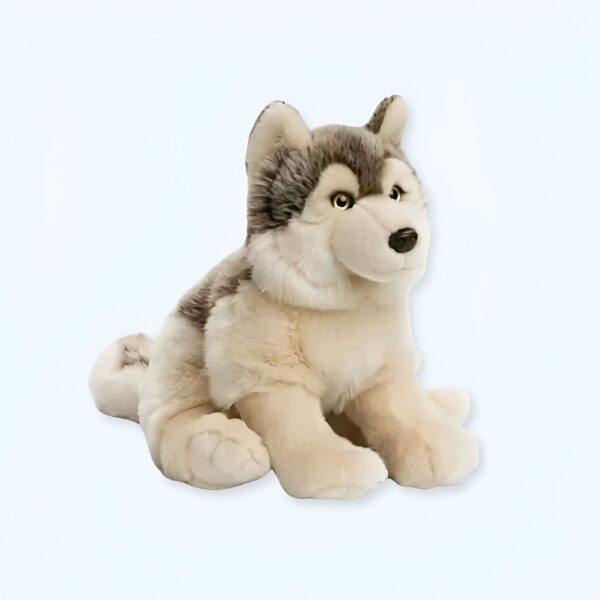 Une peluche de loup gris assis sur un fond blanc.