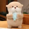 Une peluche en forme de loutre tenant un poisson bleu dans ses pattes.