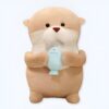 Une peluche de loutre tenant un poisson bleu.