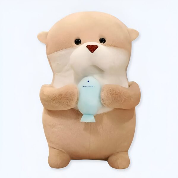 Une peluche de loutre tenant un poisson bleu.