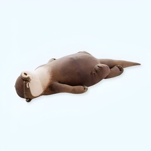 Une peluche de loutre brune allongée sur le dos, les yeux fermés.