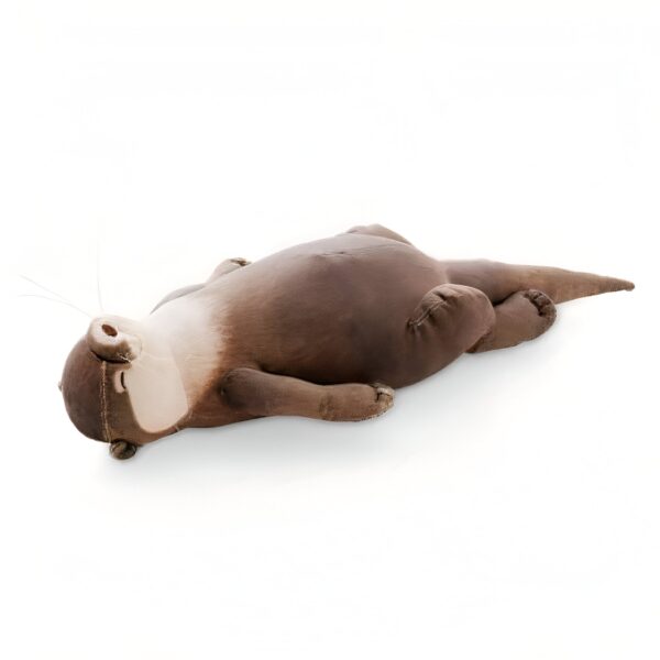 Une loutre en peluche brune allongée sur le dos, les yeux fermés, sur un fond blanc.