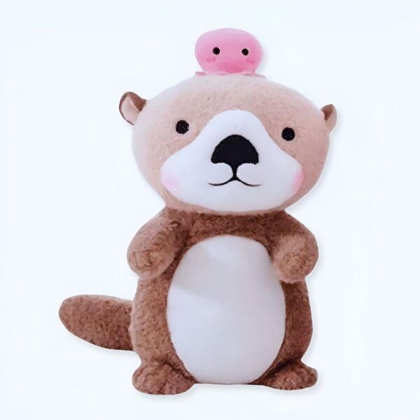 Une peluche de loutre marron avec une petite méduse rose sur la tête.