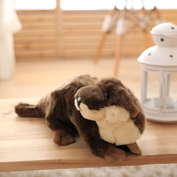 Une peluche de loutre brune et blanche posée sur une table en bois.