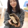 Une jeune femme tenant un adorable peluche en forme de loutre.