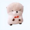 Peluche adorable en forme de loutre avec un nœud papillon rouge à pois blancs.