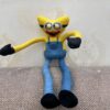 Une peluche de minion jaune avec de grands yeux, un sourire effrayant et des jambes fines.