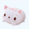 Un coussin en peluche blanc en forme de chat avec des oreilles roses et des yeux marrons.