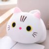 Une peluche blanche en forme de chat avec des yeux jaunes, un nez rose et des moustaches brunes.