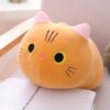 Coussin en forme de chat orange avec de grandes oreilles roses et des yeux noirs et jaunes.